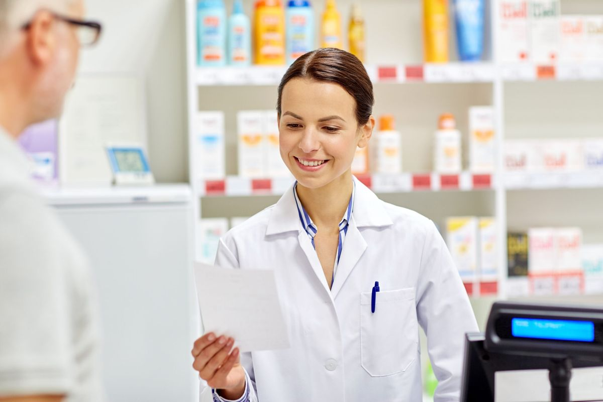 Pharmacist reading a prescription at the counter